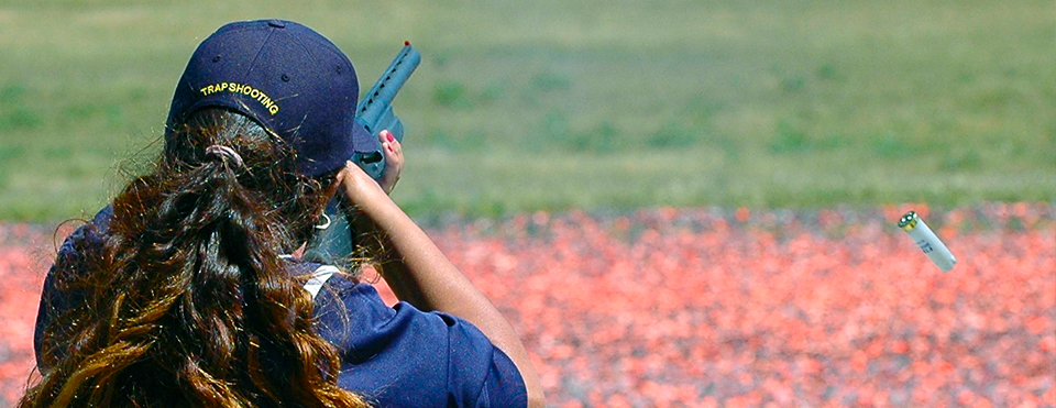 Person shooting clay target with shotgun.